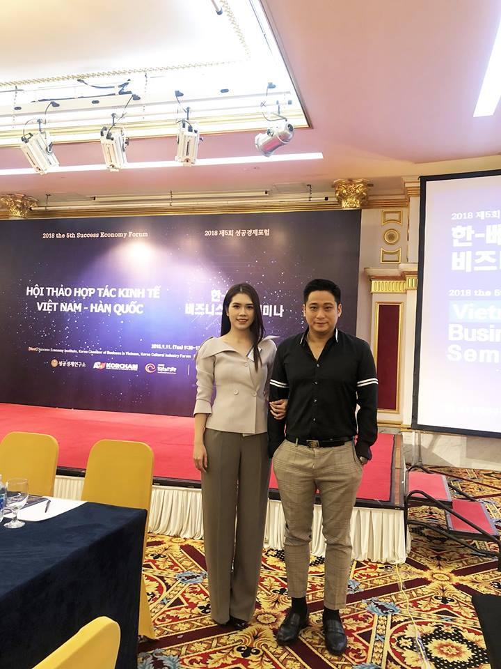 Minh Tiệp mặc áo đen, quần kẻ màu sáng lịch lãm sánh bước bên bà xã.