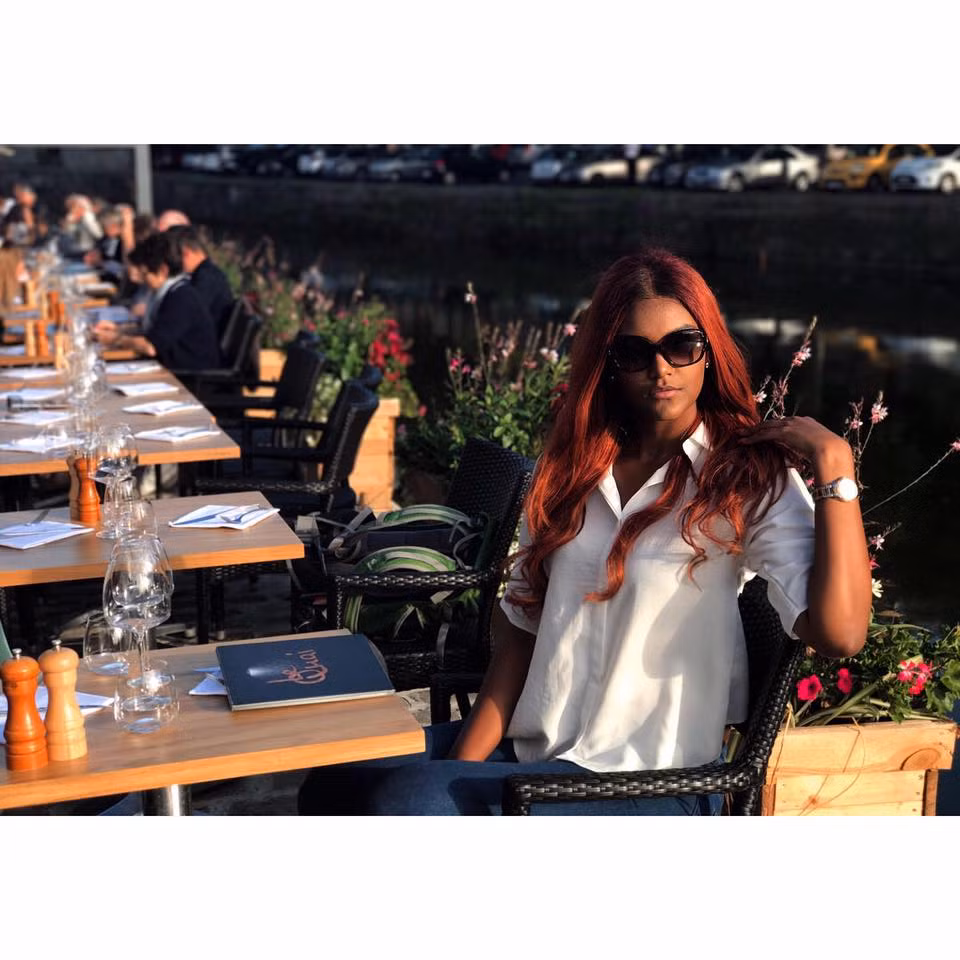 Người đẹp mặc áo sơ mi trắng, quần jean giản dị nhưng không kém phần nổi bật nhờ màu tóc nhuộm đỏ hồng và cặp kính sành điệu.