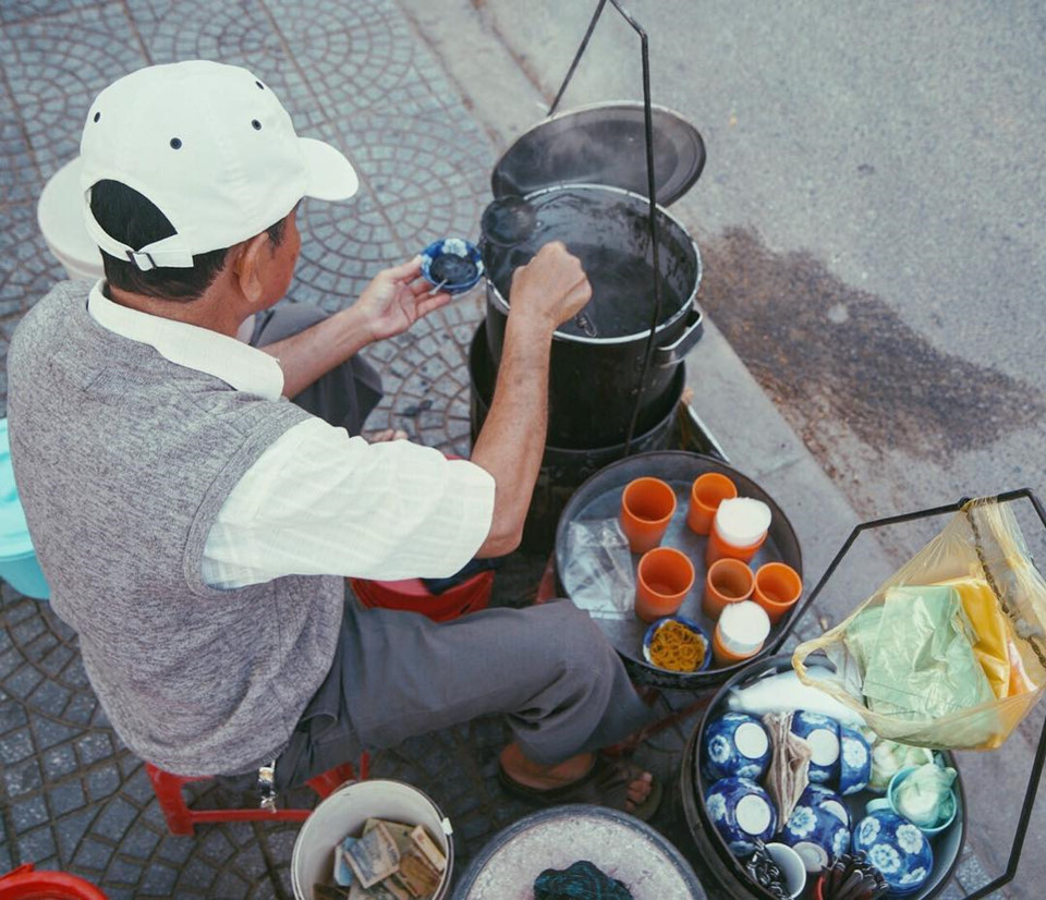 Nhiều du khách nước ngoài ấn tượng với gánh hàng rong của người dân Hội An giữa lòng phố cổ. Họ thích thú việc được ngồi ghế nhựa nhỏ, ăn bát chè nóng ngắm cảnh phố phường sau bữa chính. Ảnh: Zing.