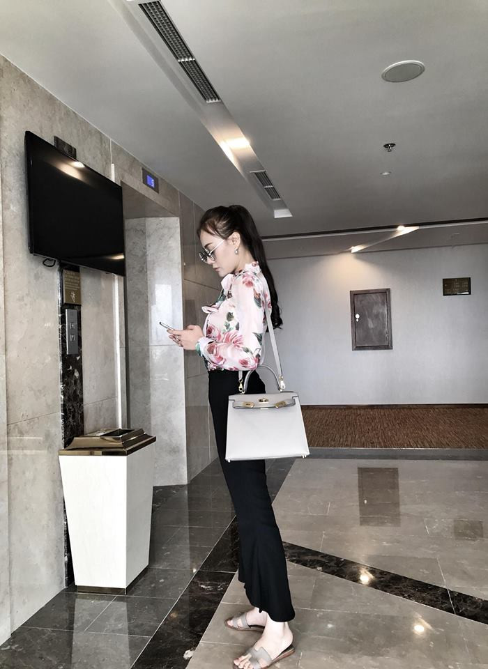 Set đồ áo sơ mi hoa và quần đen khiến cô trở nên thanh lịch.