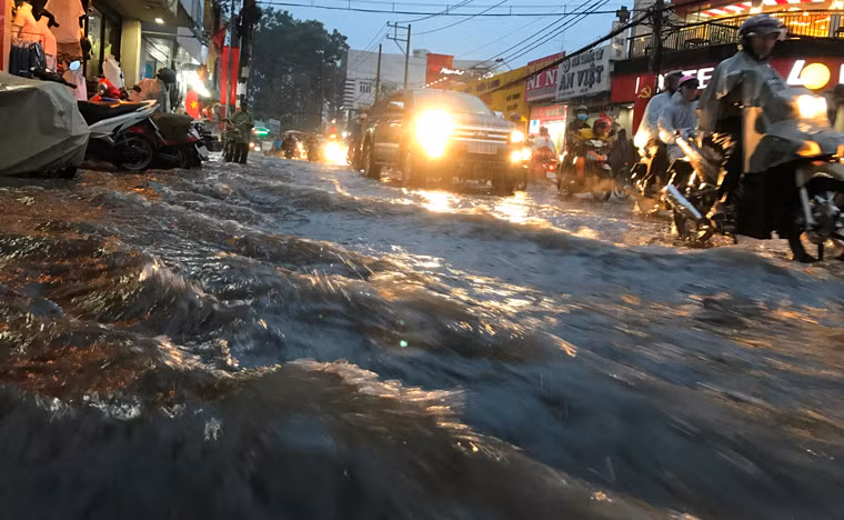 Nước mưa như thác đổ từ dốc đường Võ Văn Ngân ào ạt xuống khu vực ngã 5 chợ Thủ Đức khiến người tham gia giao thông 1 phen khốn đốn.