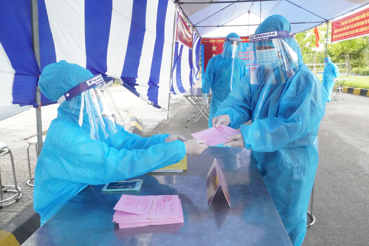 Nhận phiếu trong quần áo bảo hộ phòng dịch.