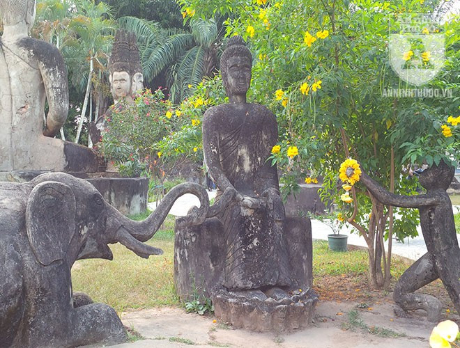 Tổ hợp tượng voi và tượng khỉ quỳ trước tượng Phật.