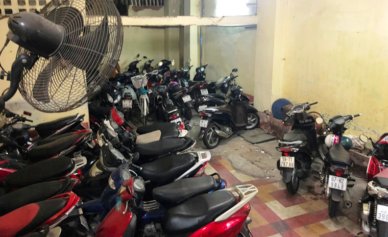 Ngay khi bước vào chung cư là khu vực để xe có diện tích nhỏ, vừa dùng để gửi xe cho cư dân và khách mua hàng, ăn uống cùng đồ đạc người buôn bán treo, đặt luộm thuộm.