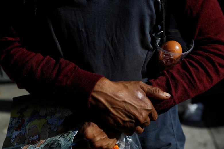 Người đàn ông giữ cẩn thận quả trứng vừa nhặt được trong thùng rác. Mời độc giả xem thêm video: Nền y tế Venezuela khủng hoảng vì bác sĩ rời bỏ đất nước (Nguồn: VTC14)