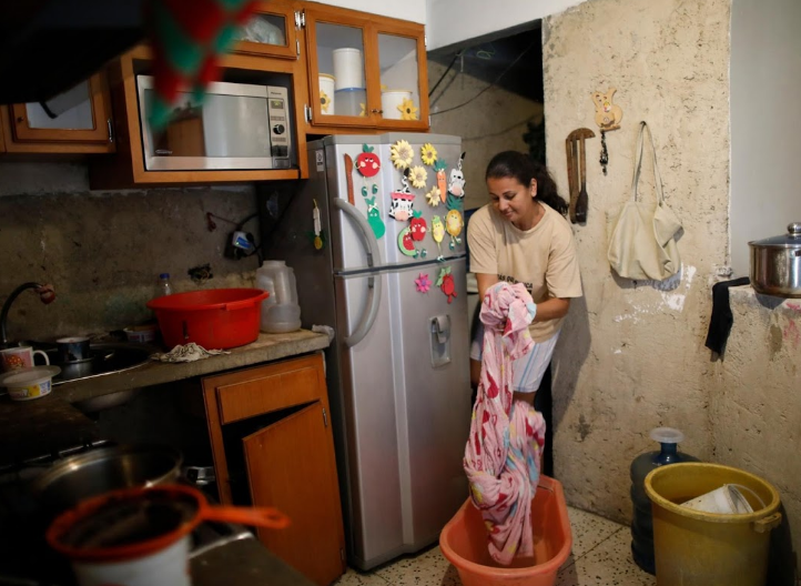 Cô Jenny Montana, 38 tuổi, giặt chăn trong nhà. Cô đang sống cùng con gái trong căn hộ trên tầng 9 của tòa nhà tập thể này. "Tôi từng phải xách nước đổ đầy 5 bình chứa 20 lít nước mỗi ngày", cô kể lại.