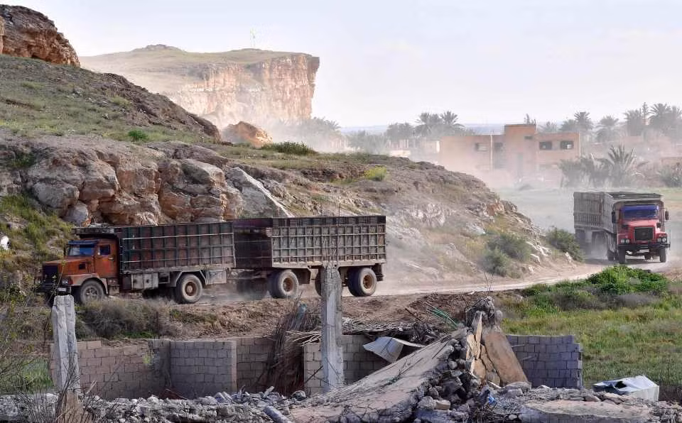 Xe tải của lực lượng SDF chở dân thường và các tay súng rời khỏi căn cứ cuối cùng ở Baghouz.