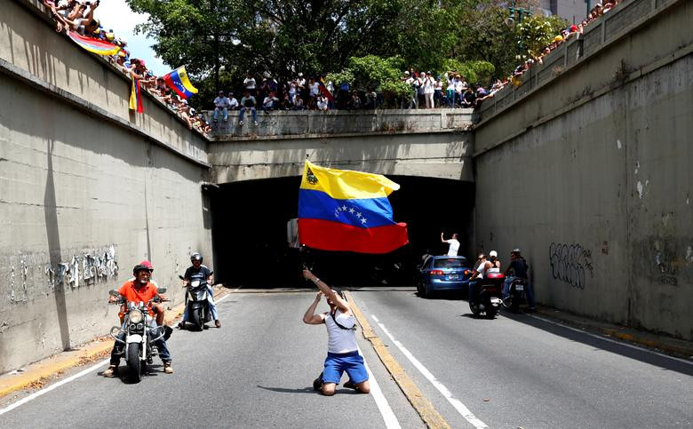 Một người ủng hộ phe đối lập Venezuela vẫy cờ trên đường phố Caracas hôm 9/3. Mời độc giả xem thêm video: Nền y tế Venezuela khủng hoảng vì bác sĩ rời bỏ đất nước (Nguồn: VTC14)