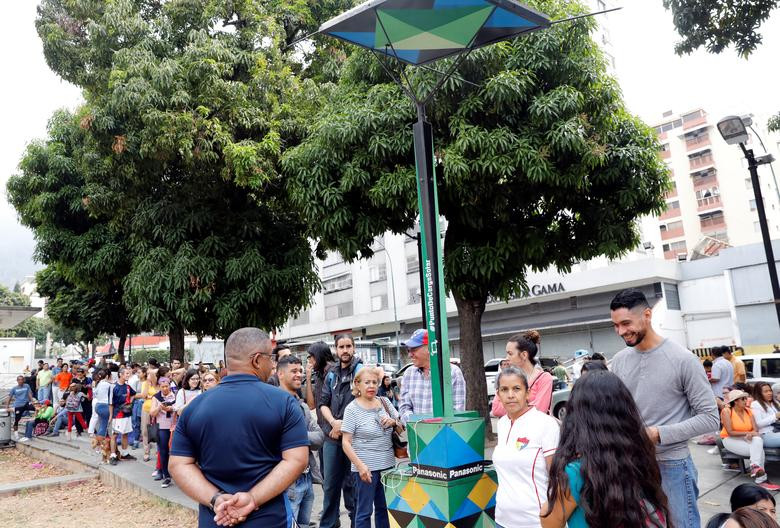 Mọi người xếp hàng để sạc pin điện thoại ngoài đường phố.