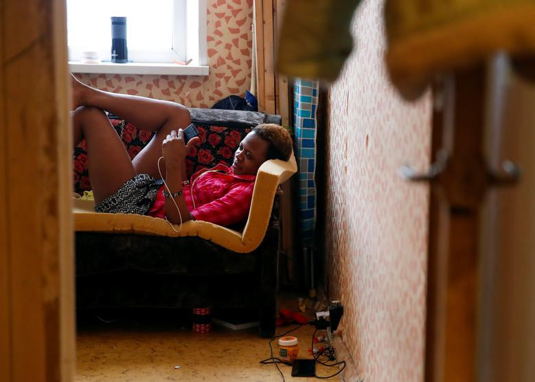 Blessing Obuson, 19 tuổi, nói chuyện qua điện thoại trong một căn phòng ở ngoại ô Moscow, Nga, ngày 21/2/2019. Cô đã được giải cứu khỏi bọn buôn người sau khi rời Nigeria để tới Moscow tìm việc.