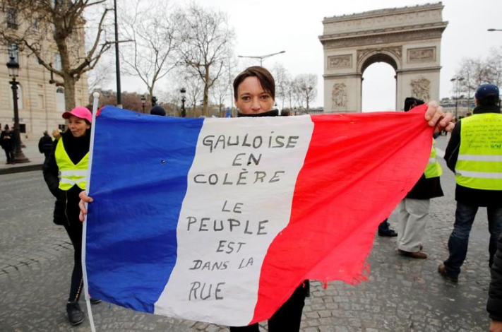 Một người biểu tình cầm cờ Pháp trước Khải Hoàn Môn ở thủ đô Paris ngày 9/3. Ảnh: Reuters.