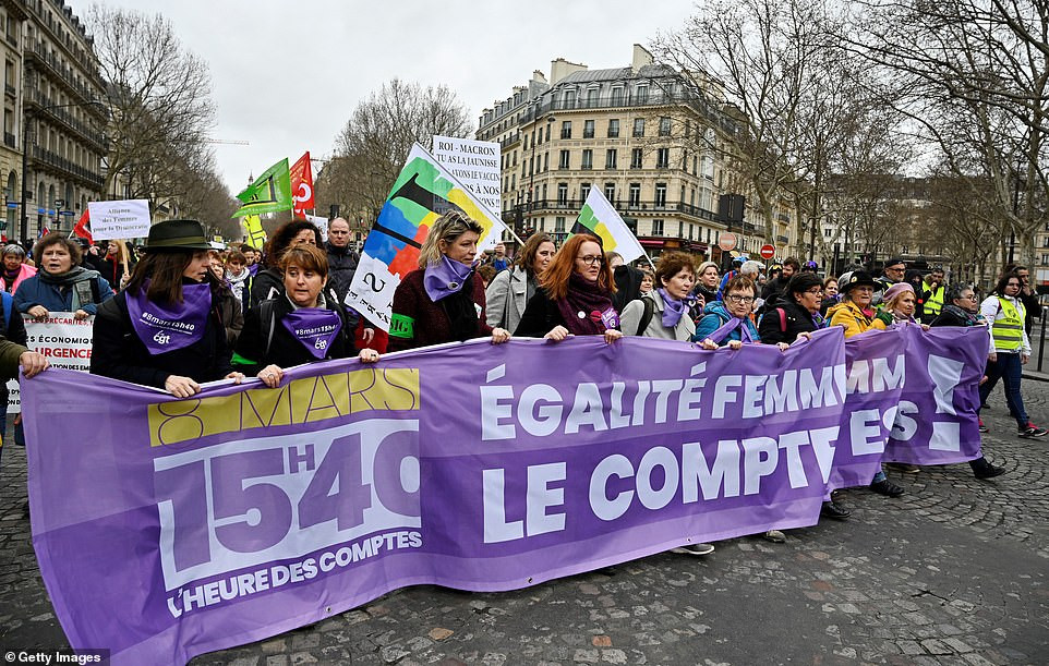 Người biểu tình "Áo hồng" mang theo băng rôn khẩu hiệu tuần hành gần Madeleine, thủ đô Paris. Ảnh: Getty.
