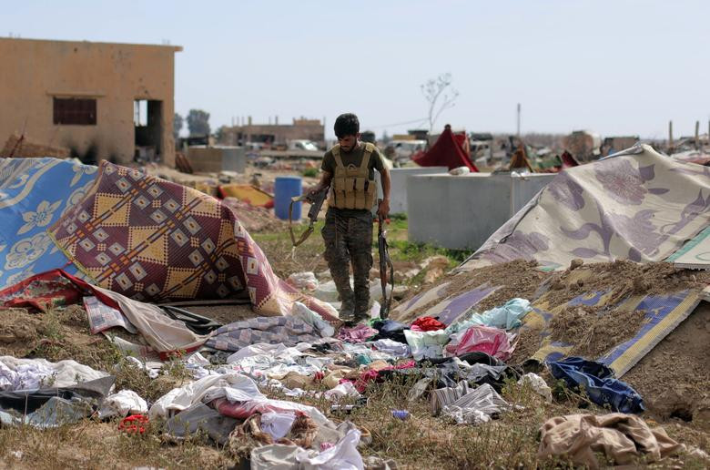 Chiến binh SDF cầm vũ khí tại ngôi làng Baghouz hôm 10/3. Ảnh: Reuters.