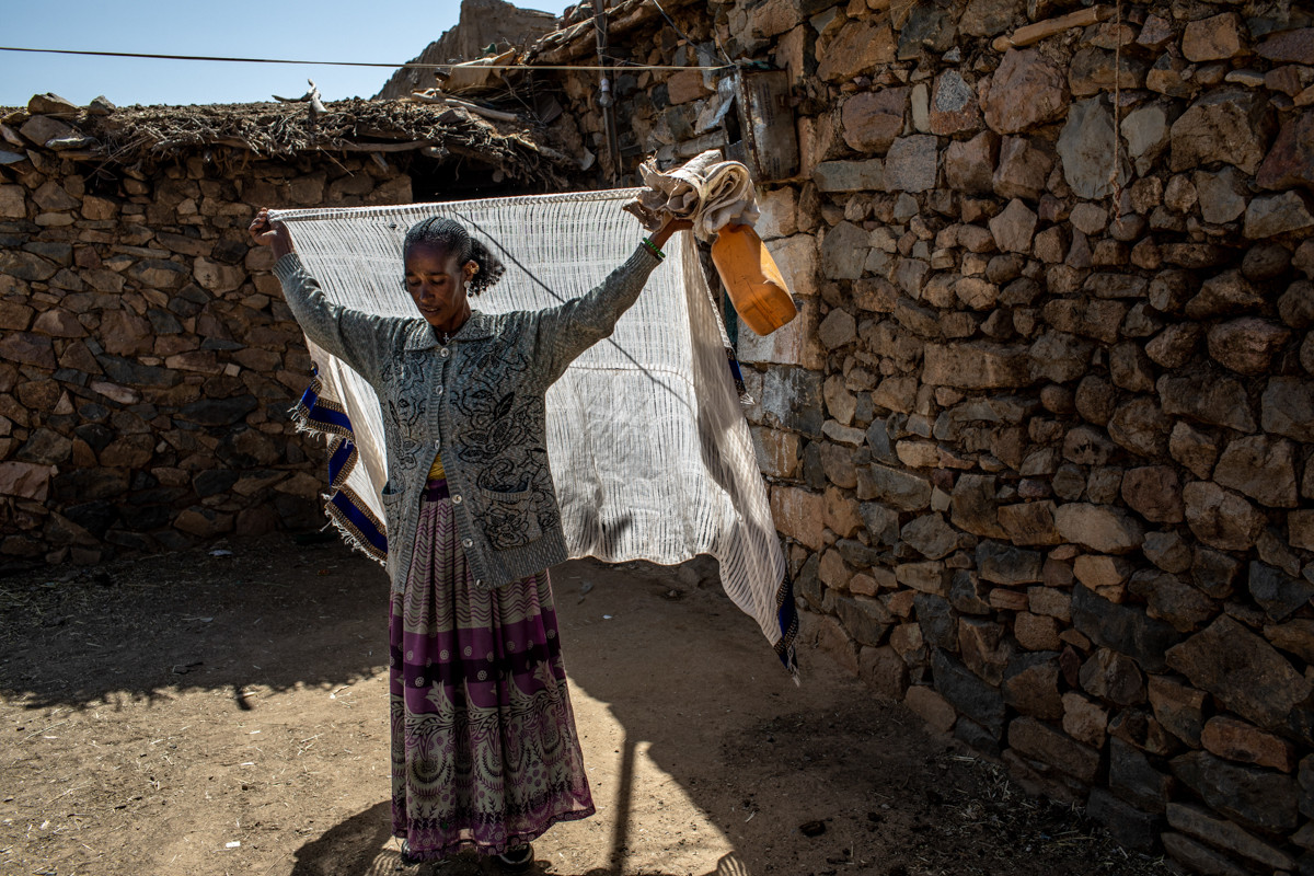Birhan, 40 tuổi, chuẩn bị đi tới điểm phân phát để nhận đồ viện trợ hàng tháng cho gia đình cô ở Hawzen, Ethiopia.