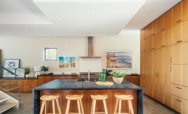 Nhà bếp rộng rãi nằm liền kề phòng khách, mang nét đẹp mộc mạc từ những nội thất được làm bằng gỗ. Khu vực này được trang bị hàng loạt công cụ nấu nướng hiện đại.