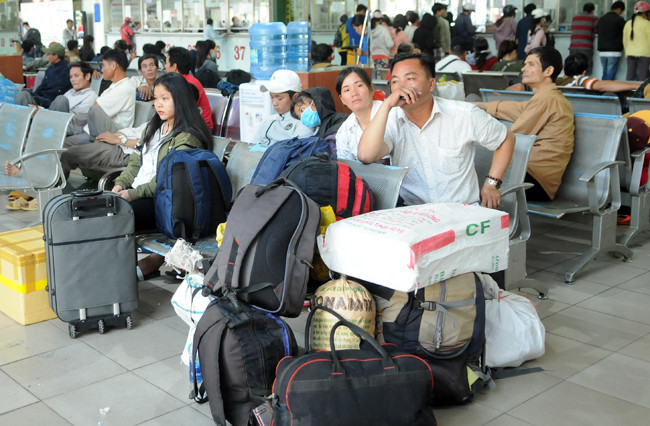 Người dân lỉnh kỉnh đồ đạc đến bến xe Miền Đông về quê đón Tết.