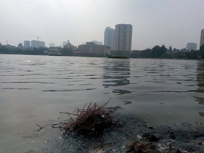 Tại hồ Giảng Võ, chân hương, tro vàng mã nổi lềnh bềnh trên mặt hồ. 