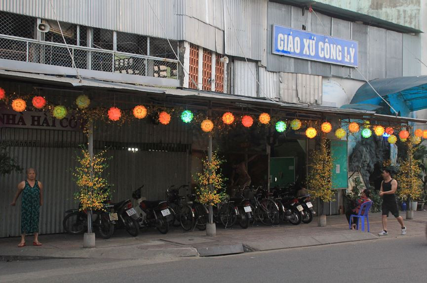 Không gian phía trước Giáo xứ Công Lý (quận 3) được điểm tô sắc xuân với những chiếc lồng đèn nhiều màu sắc cùng những cành mai vàng được khéo léo đính vào cột nhà.