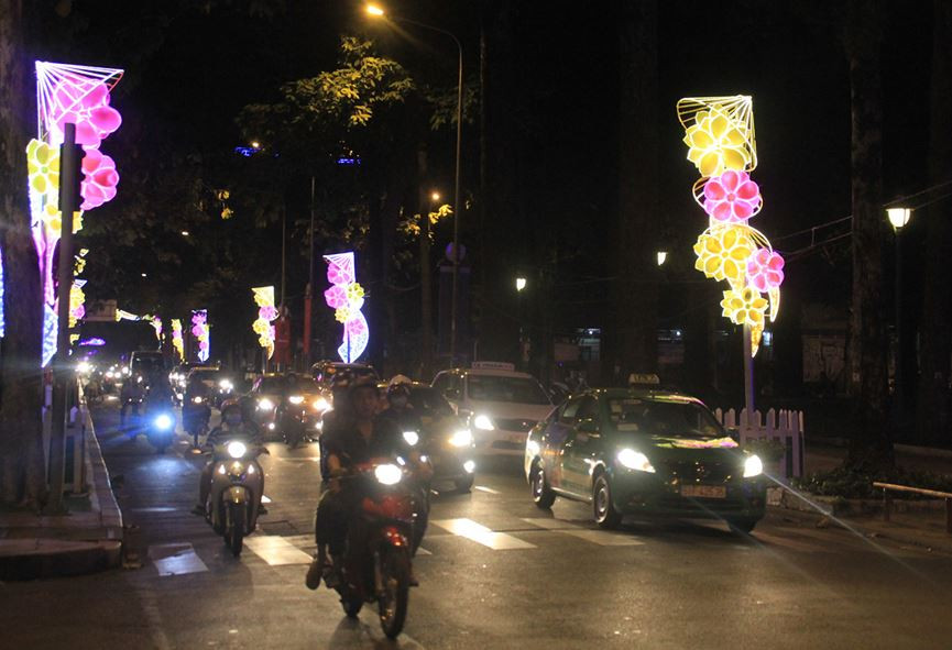 Màn đêm buông xuống, những tiểu cảnh trang hoàng hoa đào hoa mai trên khắp phố phường bừng sáng qua hệ thống đèn điện, tạo ấn tượng mạnh với người đi đường.