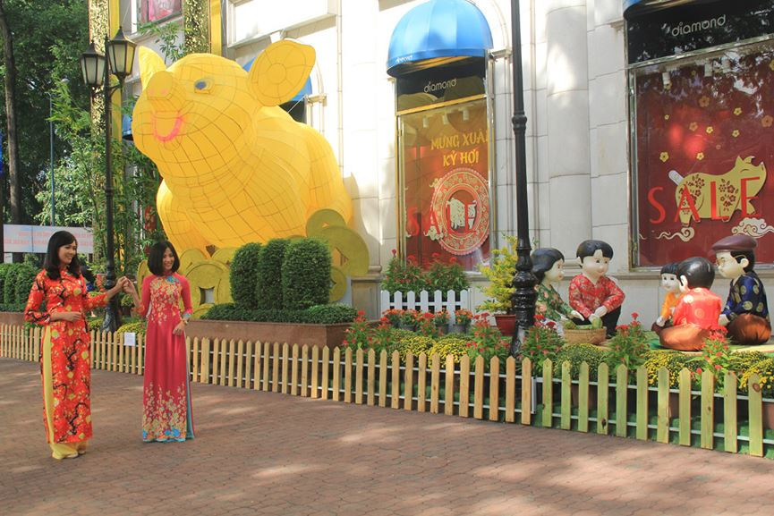 Cách đó chỉ ít bước chân, khuôn viên trung tâm thương mại Diamond trở thành địa điểm lý tưởng với nhiều người khi nơi đây trang hoàng nhiều cảnh vật bắt mắt ngày xuân như: các nhành đào mai thắm biếc, chú heo vàng thật to, cùng những chậu hoa tươi xinh xắn...