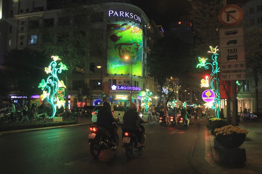 Trên các tuyến đường Nam Kỳ Khởi Nghĩa, Lê Duẩn, Đồng Khởi, Nguyễn Huệ... không khí xuân sắc ngày Tết về đã hiển diện khá sinh động với những tiểu cảnh, cổng hoa được trang hoàng chu đáo, ấn tượng. Trong ảnh: Đường Đồng Khởi lung linh về đêm với những đóa hoa ly rợp sắc xanh - vàng đan xen