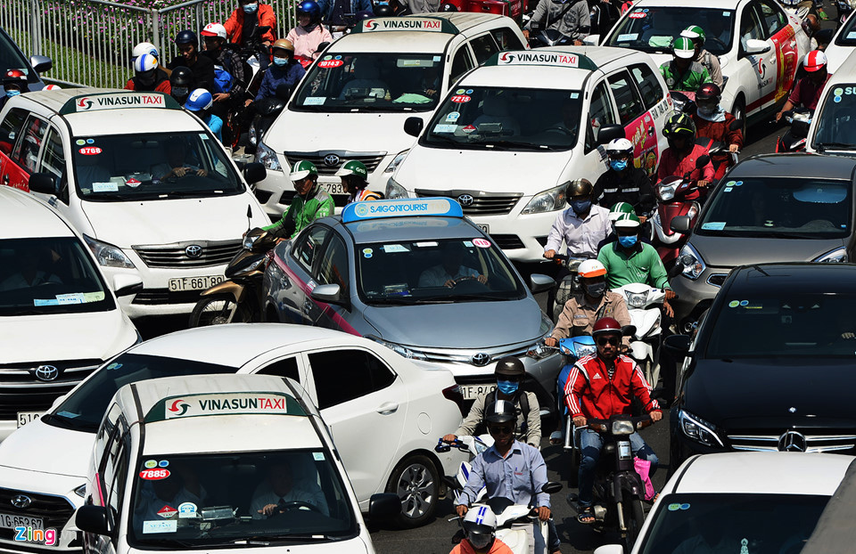 Giữa trưa, trước cổng sân bay và dưới gầm cầu vượt ôtô và xe máy chen lấn nhau nhích từng chút một.