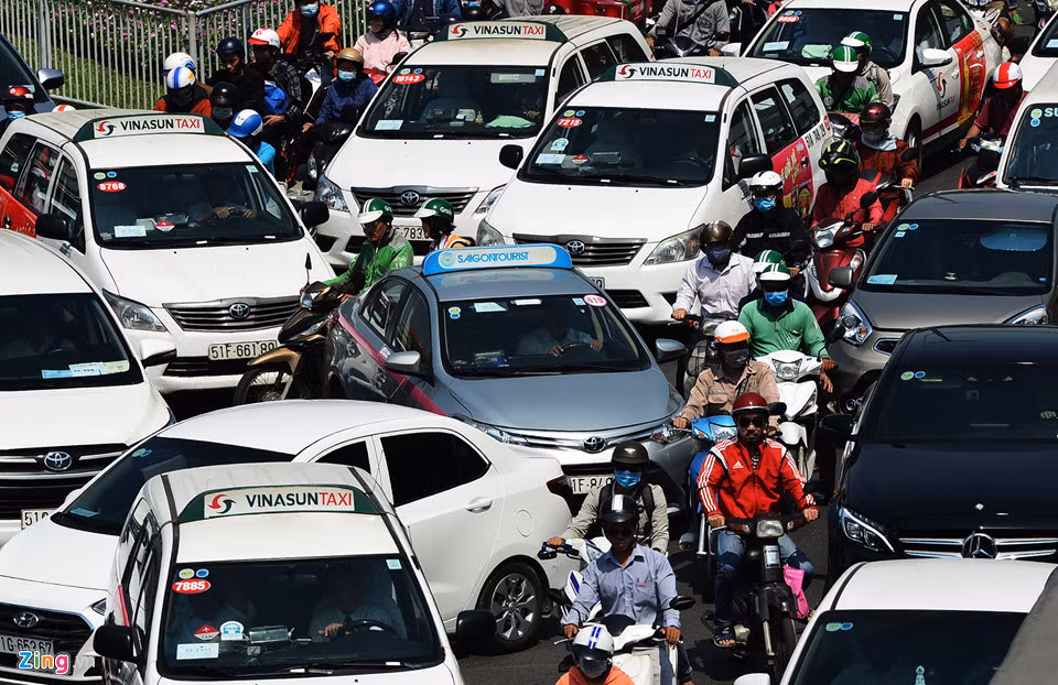 Giữa trưa, trước cổng sân bay và dưới gầm cầu vượt ôtô và xe máy chen lấn nhau nhích từng chút một.