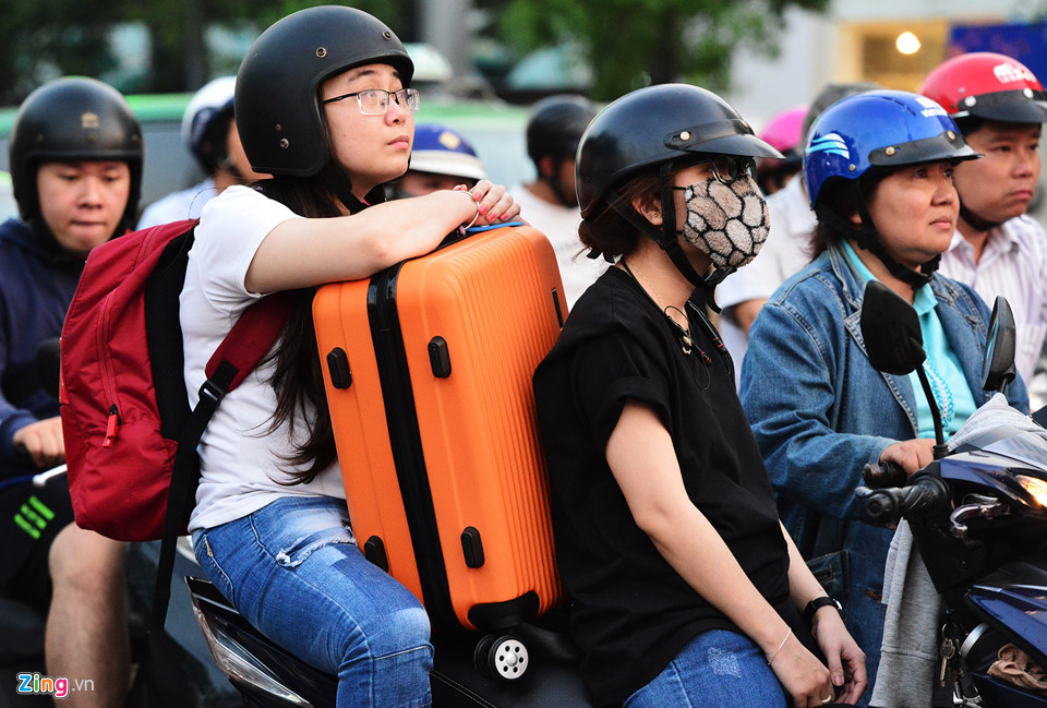 Người dân mang theo hành lý di chuyển hướng vào sân bay sốt ruột nhìn đèn tín hiệu giao thông trên đường Nguyễn Văn Trỗi.