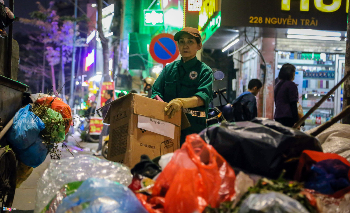 Nữ công nhân môi trường đô thị cho biết công việc của chị là đi gom rác thải từ những khu dân cư sau đó tập trung tại vỉa hè đường Nguyễn Trãi để chờ xe tới chở đi
