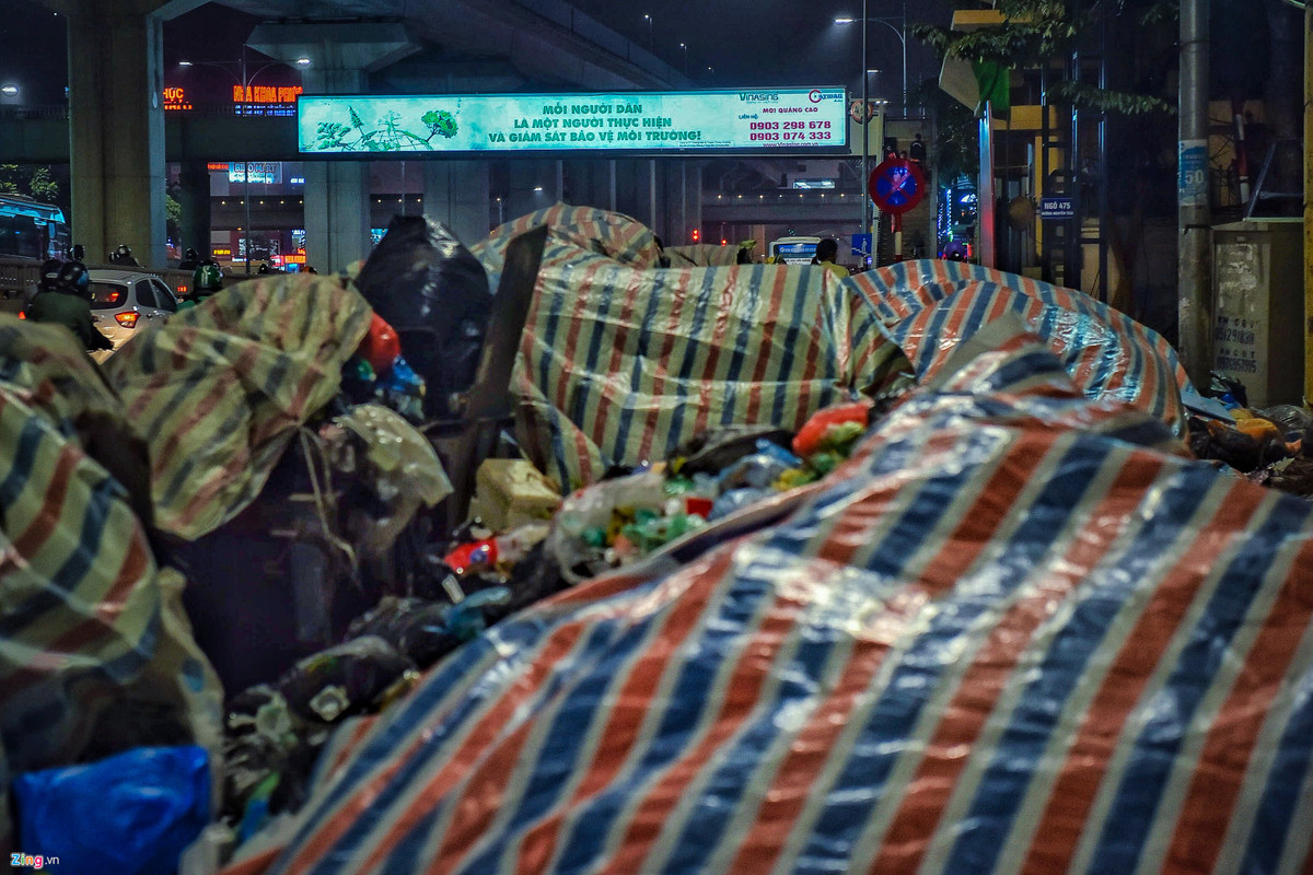 Các công nhân cố gắng bao bịt để giảm bớt mùi và không bị vương vãi ra xung quanh nhưng những đống rác cao ngất này đang dần tràn ra lòng đường.