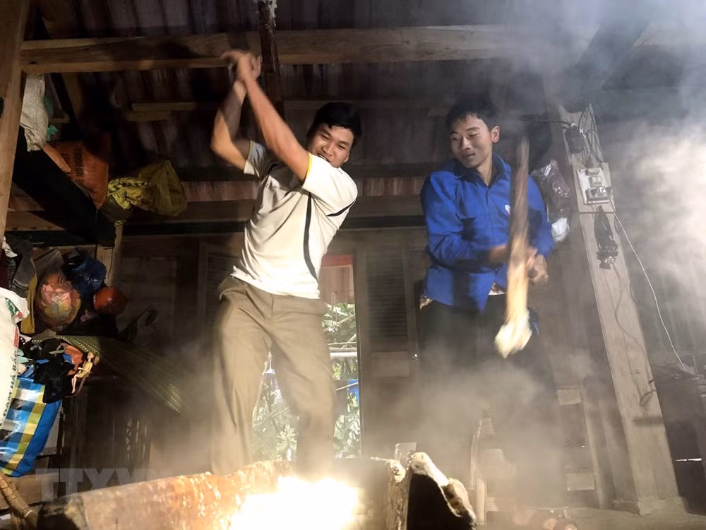 Các thanh niên tham gia giã bánh dày trong ngày tết người Mông. 
