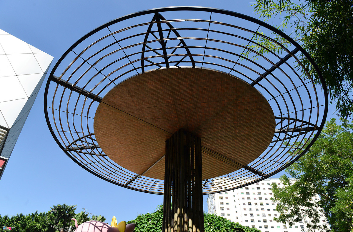 Một mái che bằng mây tre lá cùng các khóm tre nhỏ bên dưới tạo thành khung sẽ treo những giỏ hoa phong lan khi được lắp đặt trên đường hoa.