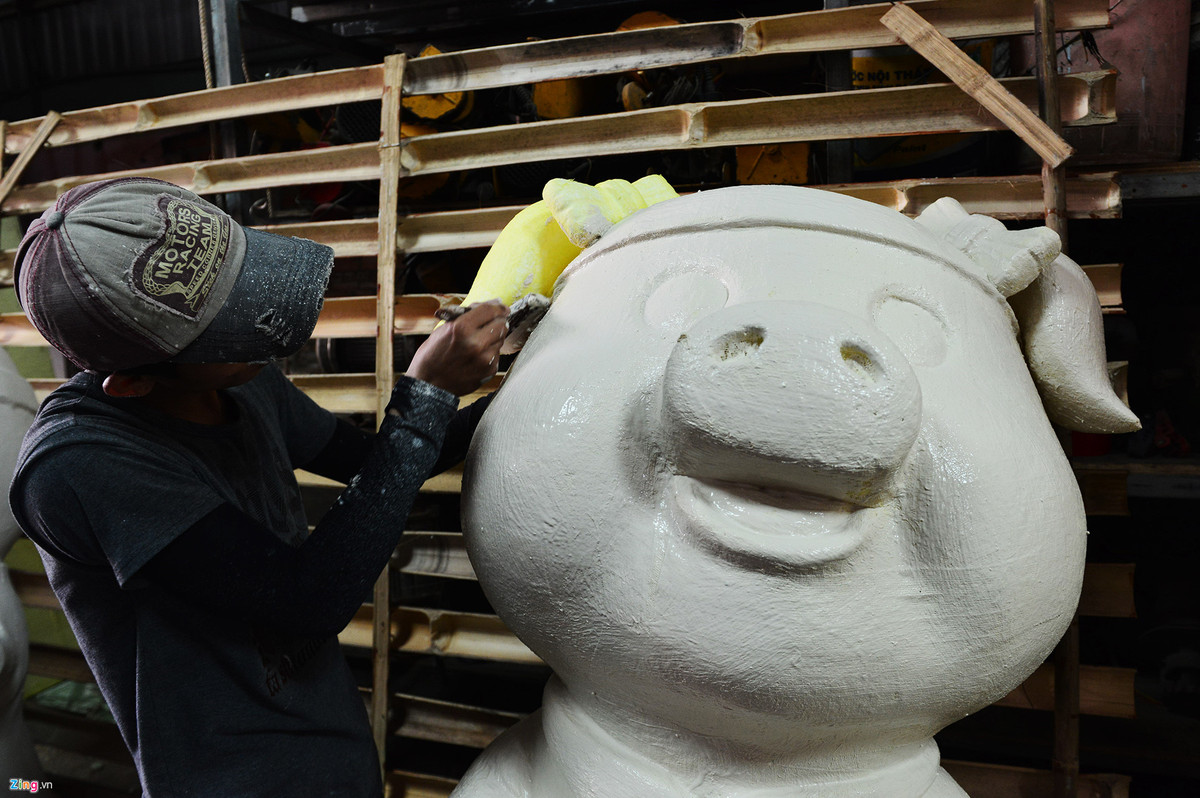 Những chú heo được tạo hình bằng xốp, sau đó sẽ được phủ các lớp màn, tiếp tục quét xi măng trắng, sơn màu, vẽ họa tiết và làm mịn trước khi mang ra trưng bày.