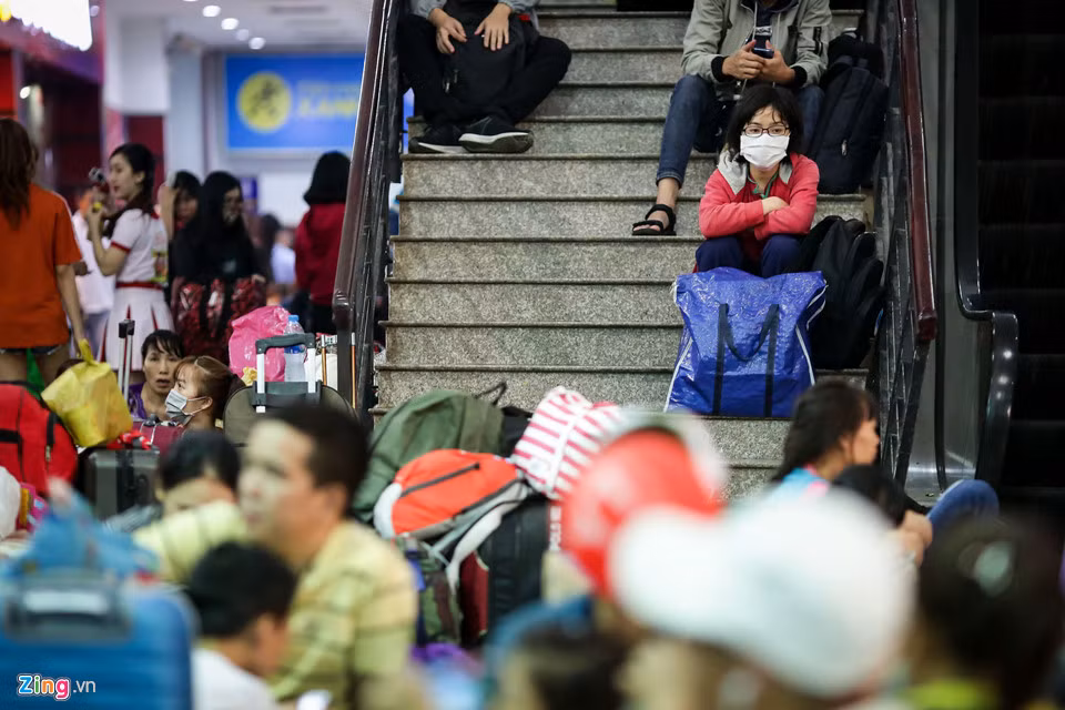 Tại ga Sài Gòn, hành khách tranh thủ ngồi chờ ở bất cứ chỗ nào có thể, từ cổng vào, sảnh ga cho đến lối đi cầu thang. Hầu hết hành khách đều lộ vẻ mệt mỏi trên gương mặt.