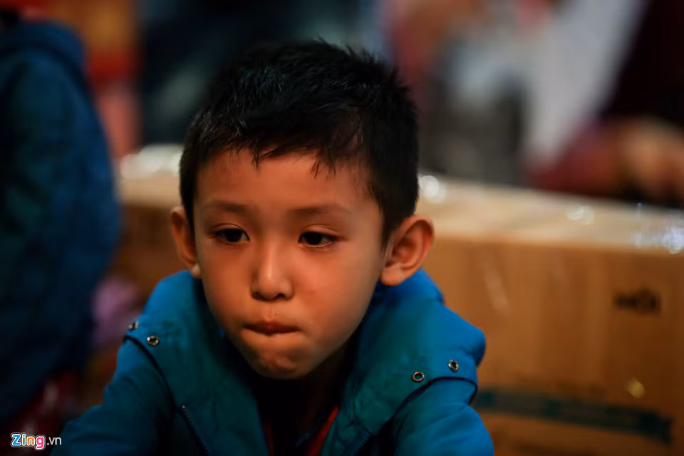 Bé Trần Duy Phát (7 tuổi) lộ vẻ chán nản khi chuyến tàu đưa gia đình bé về quê Bình Định ăn Tết bị lùi đến 3h sáng, trong khi giờ khởi hành đáng ra là 19h.