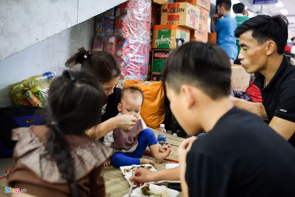 Gia đình anh Nguyễn Cao Cường đang tranh thủ ăn cơm hộp trong thời gian chờ tàu về Nam Định. Anh Cường cho hay, 10 năm nay, năm nào gia đình anh cũng đi máy bay về quê, riêng năm nay hết vé máy bay nên đành đi tàu thì gặp phải sự cố này. 