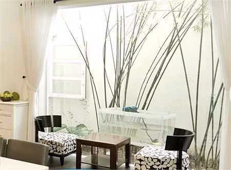 Bên trong căn biệt thự được bài trí khá nhẹ nhàng, hiện đại và đẹp mắt. Sát cửa sổ kính còn có bộ bàn ghế nhỏ nhìn ngắm khoảng vườn nhỏ bên ngoài.