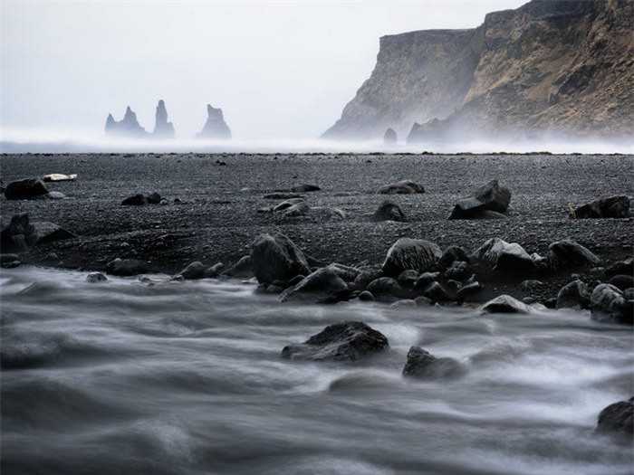  Bãi biển Reynisfjara, Iceland nổi tiếng với hai điều - bãi biển đen và những tảng đá trông đầy vẻ nguy hiểm. Giống như Punalu"u, bãi biển Reynisfjara cũng có cát đen. Ngôi làng này còn được biết đến với bộ ba khối đá bazan ấn tượng nhô ra khỏi Bắc Đại Tây Dương. Trong văn hóa dân gian Iceland, 3 tảng đá thực sự là những con quỷ bị hóa đá dưới ánh sáng mặt trời.