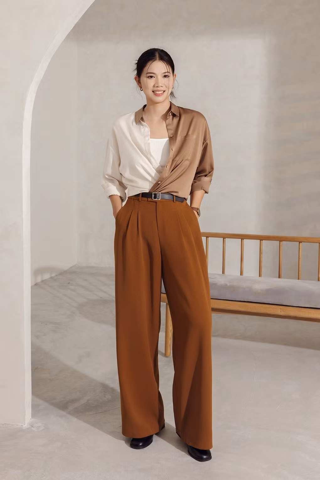 Ánh Viên tạo dáng với áo sơ mi cổ Đức phối màu nâu be, kết hợp quần ống rộng màu nâu. "Tiểu tiên cá" được khen ngày càng thăng hạng nhan sắc sau khi niềng, sửa răng và chăm chút làm đẹp. (Ảnh: Vienne Tran)