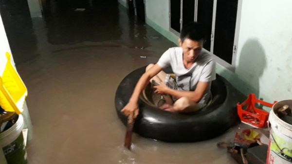 Một người dân phải dùng phao bơi để di chuyển trong chính ngôi nhà của mình.