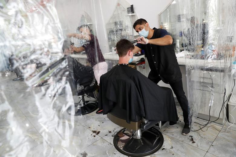 Michael Nasimov đeo khẩu trang khi cắt tóc cho một khách hàng ở Joseph Hair Salon tại Port Washington, New York, ngày 11/6. Mời độc giả xem thêm video: WHO chính thức đặt tên cho virus corona mới là SARS-CoV-2 (Nguồn video: VTC1)