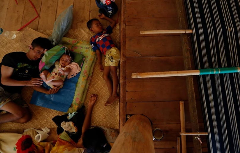 Rawa, 27 tuổi, và các con trong nhà ở làng Hamba Praing. Có thể thấy, khung dệt ở cạnh họ.