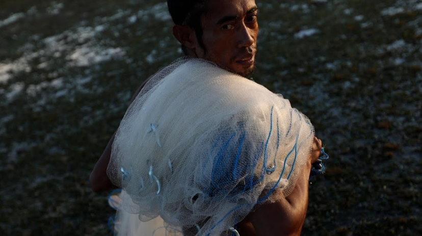 Julkarnaen Mansyur, một ngư dân 33 tuổi đến từ Waingapu, mang lưới đánh cá trở về từ bãi biển Maudolung.