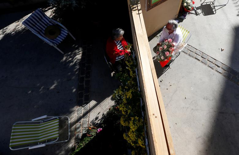 Roberto Ruiz trò chuyện với mẹ của cô, bà Elena Filippi, 80 tuổi, qua vách ngăn tại một khu dân cư ở Vina del Mar, Chile, hôm 10/5.