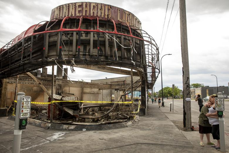 Người phụ nữ ôm con trai khi đứng trước một tòa nhà bị thiêu rụi gần nhà của họ ở Minneapolis, bang Minnesota, ngày 2/6.