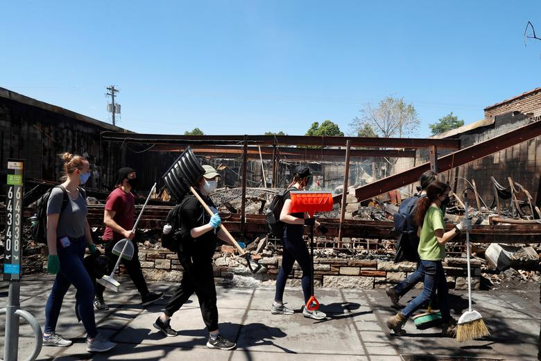 Các tình nguyện viên dọn dẹp đống đổ nát của một tòa nhà bị đốt và đổ sập trong cuộc biểu tình ở Minneapolis, ngày 30/5.