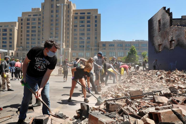 Người dân dọn dẹp đống đổ nát trong thành phố.