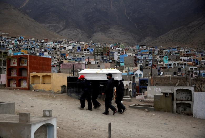 Nhân viên tang lễ khiêng quan tài chứa thi thể người tử vong vì COVID-19 đi chôn cất tại một nghĩa trang ở Lima, Peru, ngày 18/6.