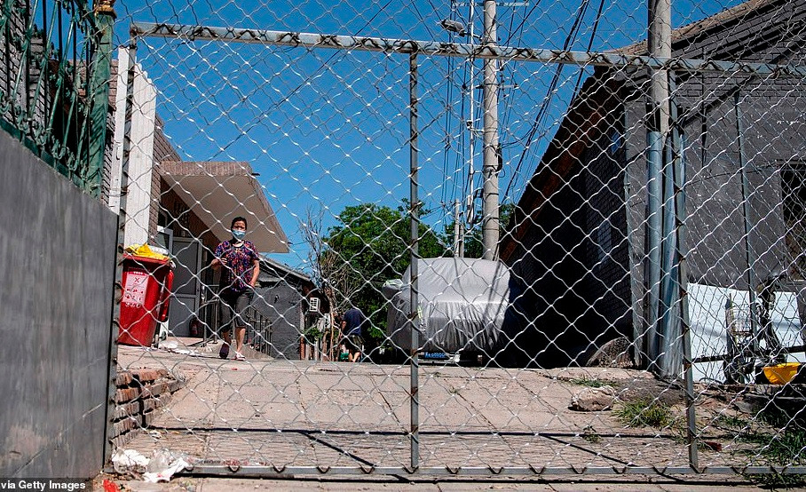 Người phụ nữ chờ nhận đồ mà cô đã đặt trên mạng tại khu dân cư Yilanyuan ngày 14/6 sau khi nơi này bị phong tỏa.Ảnh: Getty. Mời độc giả xem thêm video: WHO chính thức đặt tên cho virus corona mới là SARS-CoV-2 (Nguồn video: VTC1)