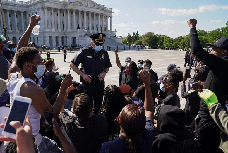 Nhóm người biểu tình quỳ gối trước một sĩ quan cảnh sát gần tòa nhà Quốc hội tại Washington ngày 1/6 để phản đối cái chết của George Floyd, người đàn ông da màu bị cảnh sát ở Minneapolis ghì cổ hôm 25/5.
